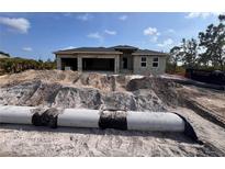 New construction home showing block structure, two-car garage, and dirt lot at 13529 Boatbill Ln, Port Charlotte, FL 33981