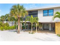 Charming beach house with mature palm trees, light siding, and covered parking at 180 N Gulf Blvd # 5, Placida, FL 33946