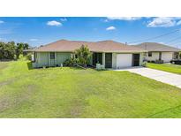 Charming single-story home with a well-maintained lawn and attached garage at 279 Mark Twain Ln, Rotonda West, FL 33947