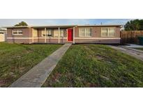 Charming single-story home with a red front door and a walkway leading to the entrance at 3157 Crestwood Dr, Port Charlotte, FL 33952