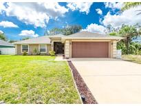 Charming single-story home featuring a well-manicured lawn and a two-car garage at 1247 Nora Ln, North Port, FL 34286