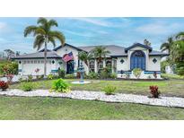 Charming single-Gathering home with a well-manicured lawn, mature palm trees and fountain at 13703 Drysdale Ave, Port Charlotte, FL 33981