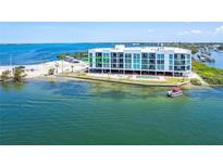 Waterfront condo building with a pool and boat access on a clear day with blue skies and turquoise water at 1375 Beach Rd # 201, Englewood, FL 34223