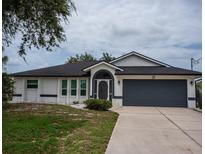 Charming single-story home with a well-manicured front yard and attached two-car garage at 21 Sportsman Way, Rotonda West, FL 33947