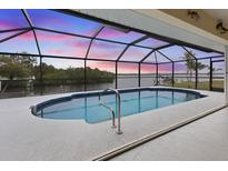Screened pool offers a stunning waterfront view and a private area for relaxation and entertainment at 2295 Chilcote Ter, Port Charlotte, FL 33981