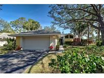 Charming single-Gathering home featuring a manicured lawn, mature trees, and a two-car garage on a sunny day at 232 Southampton Ln # 259, Venice, FL 34293