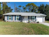 Charming single-story home featuring blue shutters and a cozy front porch perfect for relaxation at 3261 Rogue St, North Port, FL 34291