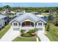 Stunning elevated home features a metal roof, two-car garage, and beautiful landscaping and water access at 4219 Spire St, Port Charlotte, FL 33981