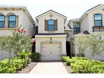Charming townhouse featuring a one-car garage and well-manicured front yard with flowering bushes at 5009 Skyview Ln, Bradenton, FL 34211