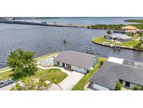 Waterfront home featuring a metal roof, dock, and serene water views at 5174 Conner Ter, Port Charlotte, FL 33981