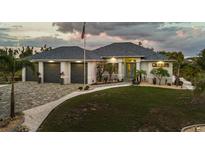 Beautiful single-story home featuring manicured lawn, three-car garage, and charming landscaping at 530 Spaniards Rd, Placida, FL 33946