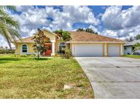 Charming single-story home with a three-car garage, a well-manicured lawn, and a bright, inviting facade at 59 White Marsh Ln, Rotonda West, FL 33947