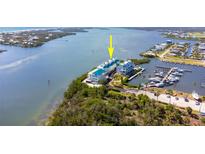 Waterfront condos with marina access; white exteriors, turquoise roofs, lush surroundings at 8005 Bay Pointe Dr, Englewood, FL 34224