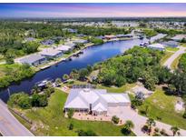 Stunning aerial view of waterfront home with pool, lush landscaping, boat dock and seawall at 8127 Consul St, Port Charlotte, FL 33981