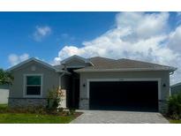 Charming single-story home with a modern exterior, well-manicured lawn, and inviting curb appeal under a bright blue sky at 8360 Waterscape Rd, Englewood, FL 34224
