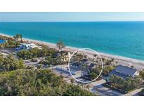 Breathtaking aerial view of a beachfront home with lush landscaping and stunning ocean views at 8500 Manasota Key Rd, Englewood, FL 34223