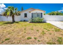 Charming single-story home with a well-maintained yard and a white fence, creating a cozy curb appeal at 859 E 2Nd St, Englewood, FL 34223