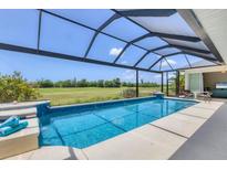 Inviting screened pool area with a clear blue pool, golf course view, and outdoor seating, perfect for relaxation and entertainment at 1002 Rotonda Cir, Rotonda West, FL 33947
