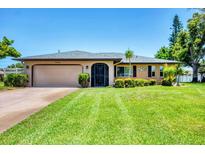 Charming single-story home with a manicured lawn, mature landscaping, and a convenient two-car garage at 1040 Caples St, Englewood, FL 34223