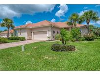 Charming single-story home with tile roof, attached garage, and lush tropical landscaping at 13051 Creekside Ln, Port Charlotte, FL 33953
