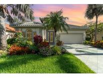 Charming home featuring lush landscaping, a tile roof, and a well-manicured lawn at 13376 Golf Pointe Dr, Port Charlotte, FL 33953