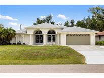 Charming single Gathering home featuring a manicured lawn and arched entryways to enhance curb appeal at 18112 Windswept Av, Port Charlotte, FL 33948