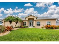 Charming single-story home featuring a well-manicured lawn, mature trees, and an inviting front entrance at 22 Par View Rd, Rotonda West, FL 33947