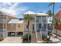 Charming two-story home with colorful exterior and a welcoming front porch with white railing at 11780 Anglers Club Dr # 107, Placida, FL 33946