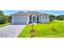 Charming single-story home featuring a paved driveway and lush green lawn at 123 Ferdon Cir, Port Charlotte, FL 33954