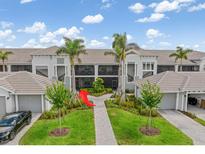 Beautiful building exterior with lush landscaping and private garages at 12550 Galapagos Ct # 104, Venice, FL 34293