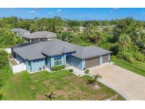 Lovely single-story home with a three-car garage and lush landscaping at 1269 N Lavina St, North Port, FL 34286