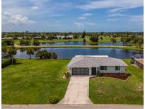 Beautiful waterfront home with mature landscaping and views of a scenic lake and golf course at 15 Oakland Hills Pl, Rotonda West, FL 33947