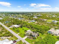 Beautiful community featuring lush tropical landscaping, waterways, and well-maintained homes at 15521 Lakeland Cir, Port Charlotte, FL 33981