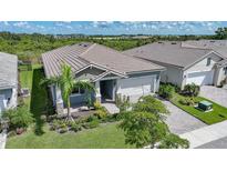 Charming home with a well-manicured lawn, lush landscaping, and a tile roof at 17921 Grand Prosperity Dr, Venice, FL 34293