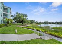 Beautiful community lake view with lush landscaping, pathways and building access, perfect for relaxing strolls at 19375 Water Oak Dr # 203, Port Charlotte, FL 33948