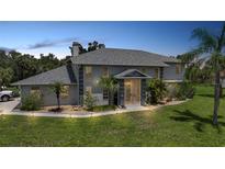 Stately two-story home featuring lush landscaping, a portico entrance, and mature palm trees at 196 Lecturn St, Port Charlotte, FL 33954