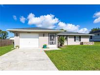 Charming single-story home with a well-maintained lawn, attached garage, and inviting front entrance at 3085 Crowder St, Punta Gorda, FL 33980