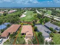 Expansive aerial view of property showcasing lush landscaping, golf course, and serene lake views at 3207 Village Ln, Port Charlotte, FL 33953
