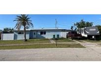 Single story home with a lawn, palm tree and an RV parked in the driveway at 700 Floral Ln, Port Charlotte, FL 33952