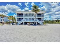 Stunning beachfront home featuring dual balconies and stairs with a palm tree accent at 7554 Palm Island S Dr # 1813, Placida, FL 33946