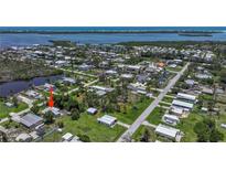 High aerial view of the neighborhood and surrounding waterways, dotted with lush trees at 8224 Pinetree Ln, Englewood, FL 34224