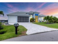 Beautiful single-Gathering home features a well-manicured lawn, paver driveway, and a two-car garage at 10079 Lebanon Dr, Port Charlotte, FL 33981