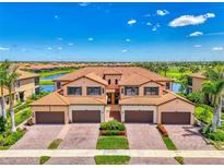 Beautiful Mediterranean-style villa with a clay tile roof, paver driveway, and lush landscaping at 10788 Tarflower Dr # 201, Venice, FL 34293