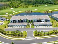 Beautiful aerial view of condo building overlooking golf course, pond and garages with palm trees at 12470 Wellen Golf St # 107, Venice, FL 34293