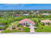 A beautiful front exterior shot of the house with a well-manicured lawn and tropical landscaping at 200 Arlington Dr, Placida, FL 33946