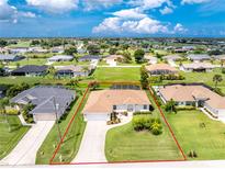 An aerial view of a single-Gathering home featuring lush landscaping and a screened-in pool, showcasing the property's well-maintained exterior at 25 Mariner Ln, Rotonda West, FL 33947