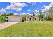 Charming single-story home featuring a well-manicured lawn and attached two-car garage at 2679 Armenia Rd, North Port, FL 34286
