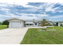Charming single-story home with an attached garage, well-manicured lawn, and a delightful landscaped flowerbed at 39 Caddy Rd, Rotonda West, FL 33947