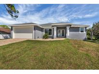 Charming single-story home with a gray exterior, well-manicured lawn and two-car garage at 5781 Elton Rd, Venice, FL 34293