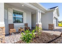 Inviting front porch featuring stone accents and an outdoor seating area at 14756 Ponce De Leon Trl, Port Charlotte, FL 33981